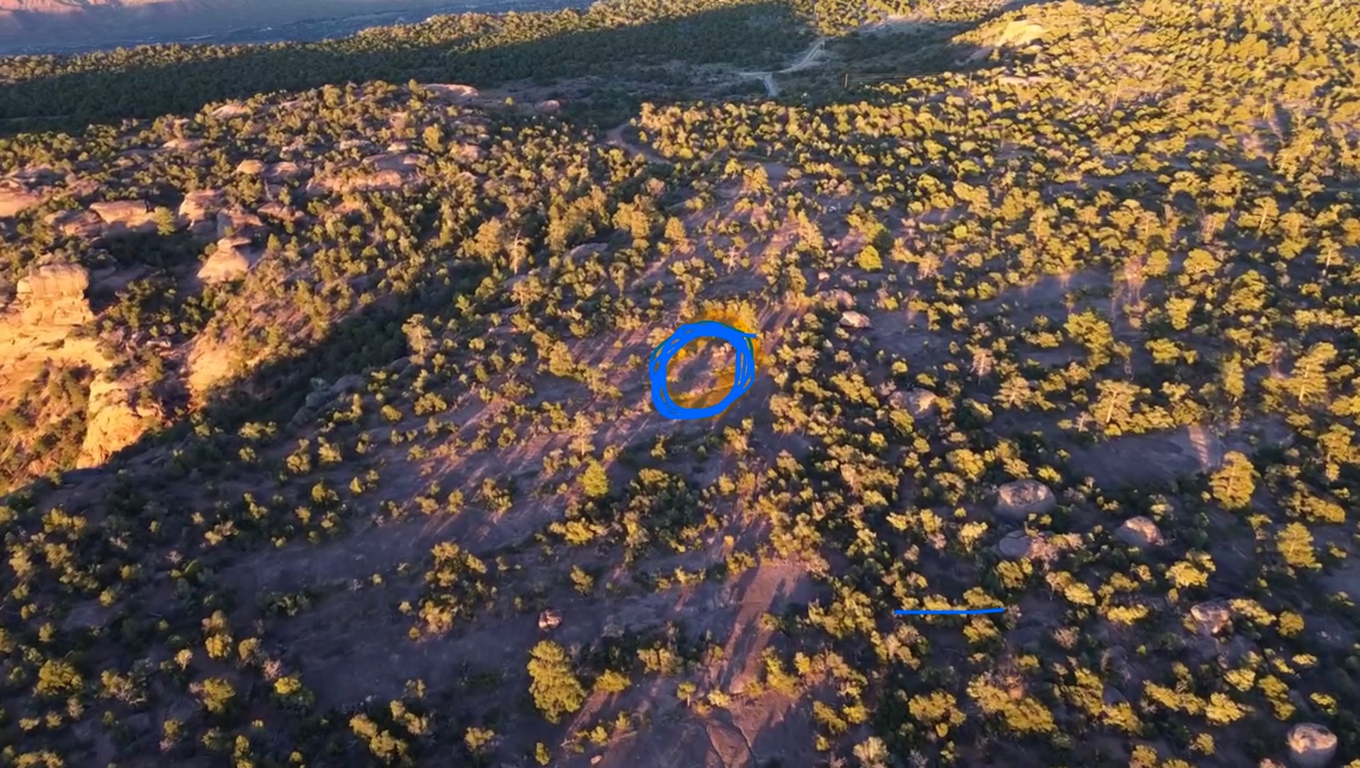 Aerial drone view of the slickrock bench site, with a hand-drawn blue circle marking the track location.